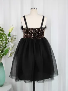Detail of a girl's black mesh dress featuring bronze sequins and soft feather trim