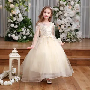 Detailed embroidery on a champagne girls princess dress with layered tulle and satin bow