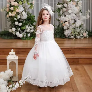 Close-up of white flower girl dress featuring intricate lace floral patterns and mesh sleeves