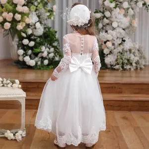 Detail of white flower girl dress featuring lace trim and a large satin back bow