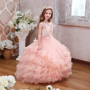 Close-up of pink luxury girls dress with layered mesh tulle, lace flowers and soft feathers