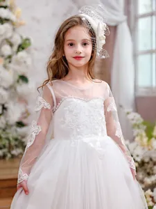 Detailed close-up of white princess dress featuring lace appliques and puffy tulle layers