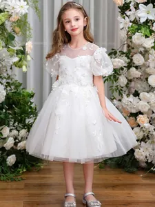 Detailaufnahme von weißem Blumenmädchenkleid mit floraler Stickerei und Puffärmeln