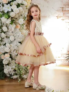 Sleeveless champagne flower girl dress with layered tulle skirt and satin bow for gala