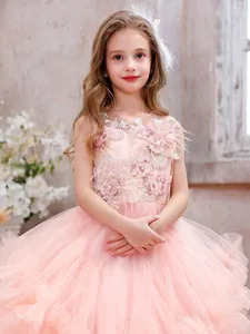 Close-up of pink girls formal dress with 3D floral appliqués and feather bodice details