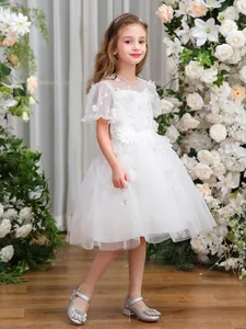 Detail des weißen Blumenmädchenkleids mit Tüllschichten und floralen 3D-Applikationen