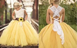 Detail of flower girl dress showing sunflower belt, yellow mesh skirt and lace back straps