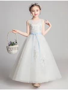 Detail of white flower girl dress with blue floral embroidery and tulle layered skirt