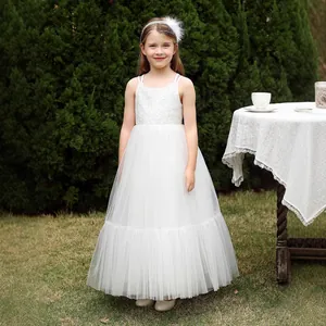 Detalle del corpiño de encaje delicado y el tul de varias capas en el vestido blanco de niña
