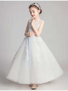 Detailed close-up of premium white lace embroidery and multi-layer tulle on a girl's dress