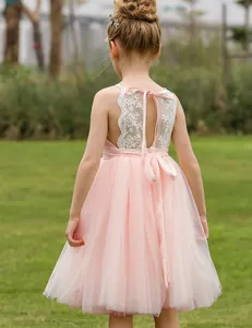 Detalle posterior del vestido rosa de niña con encaje de copos y lazo de satén
