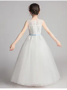 Detail of white girls' formal dress showing delicate lace embroidery and mesh layers