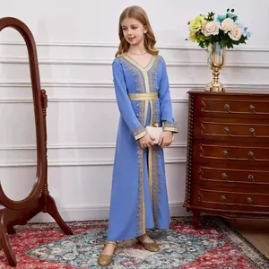 Close-up of light blue girl's kaftan with intricate golden lace embroidery details
