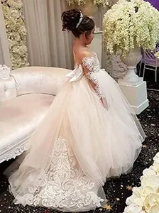 Detalle de la cola de tul con bordado de encaje y gran lazo de seda en el vestido de niña