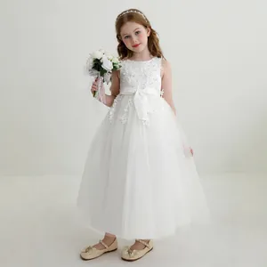 Close-up of sleeveless white lace floral embroidery and ribbon bow on girl's princess gown