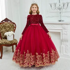 Detailed view of dark red girls' gown with sequins, waist bow and gold embroidery on tulle