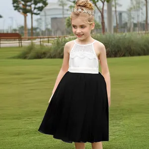 Detalle del corpiño halter de encaje blanco bordado en el vestido de tul negro para niña