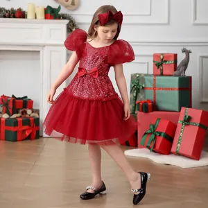 Detailed close-up of a girl's red sequin princess dress with a bow headband in a festive setting