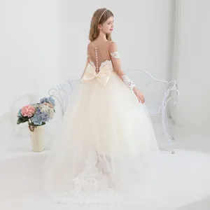 Detalle del elegante vestido de tul para niña con botones de perlas y lazo trasero
