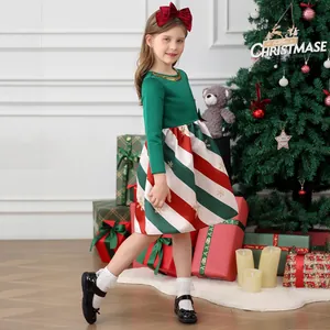 Detail view of girls Christmas dress featuring candy cane stripes and gold snowflake prints