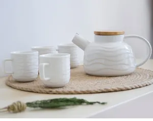 Vue détaillée de la théière en céramique blanche texturée sur un set de table en jute