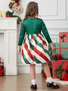 Christmas girl dress with green satin top and red white striped skirt in holiday setting
