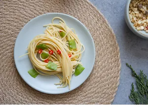 Vue détaillée d'un set de table rond en jute tressée à la main sous une assiette en céramique