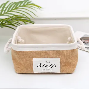 Detail of jute storage basket with cotton rope handles and woven label on white surface