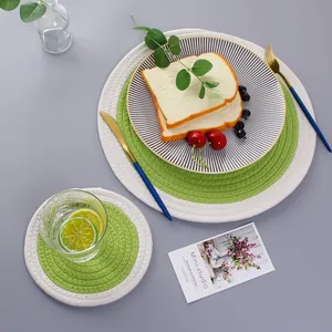 Detail of round woven cotton placemat with green and white bi-color braided texture