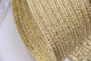 Gros plan sur la texture tissée dorée métallique et les détails rayés du set de table rond