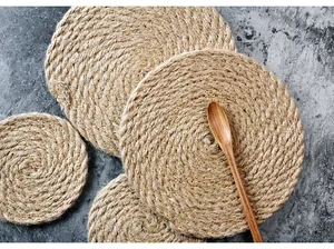 Détail macro de sets de table ronds en jute naturelle avec texture tissée sur pierre sombre