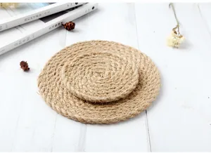 Gros plan de sets de table ronds en jute avec texture tissée en spirale sur bois
