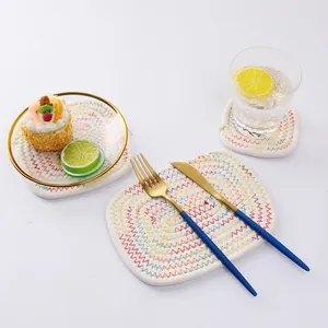 Set di tovagliette in cotone fatte a mano con cuciture arcobaleno su sfondo bianco