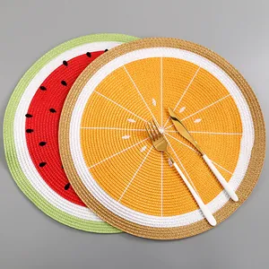 Detailaufnahme runder geflochtener Tischsets mit Melonen- und Orangenmotiven für den Tisch