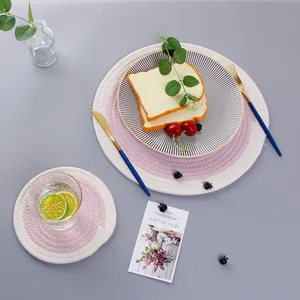Detail of round cotton braided placemat and coaster set with pink and white design