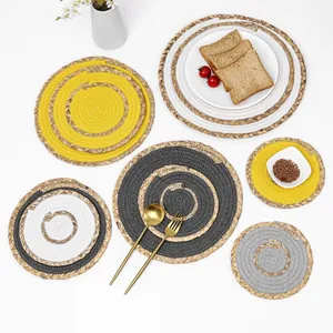 Close-up of assorted round woven placemats in grey and white showing intricate hand braiding