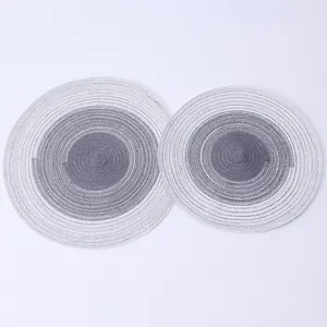 Close-up of grey and white gradient woven round placemats with spiral cotton texture