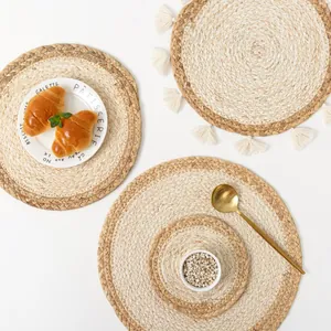 Detail of round woven straw placemats with fringe edge and spiral natural texture