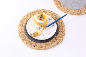 Détail de set de table rond tressé en paille naturelle avec design bicolore