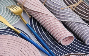 Macro detail of round woven cotton table mats showing colorful spiral stitch textures