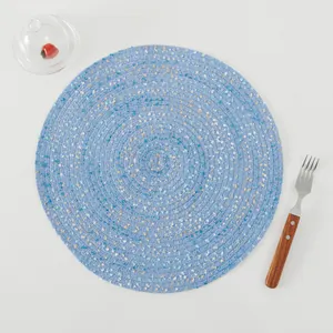 Top view of a round woven heat-resistant placemat in light blue with subtle color speckles