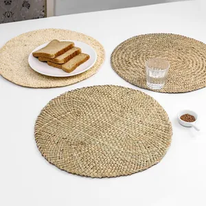 Three-piece set of round woven heat-resistant placemats in natural corn husk material