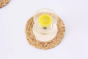 Détail d'un dessous de verre tissé rond avec centre en coton blanc et bord en paille