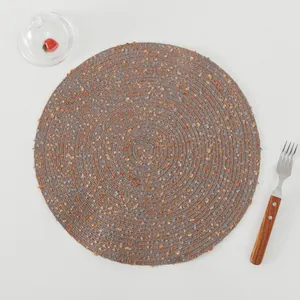 Macro detail of round woven heat-resistant table mat with grey fiber and orange specks