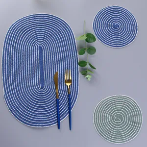Close-up of woven ramie placemat set with oval navy and round sage green cup mats