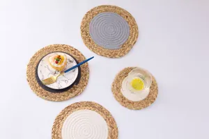 Détail de sets de table circulaires mêlant paille naturelle et corde de coton bicolore