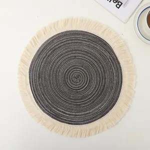 Close-up of circular woven ramie placemat with gray spiral pattern and fringe trim