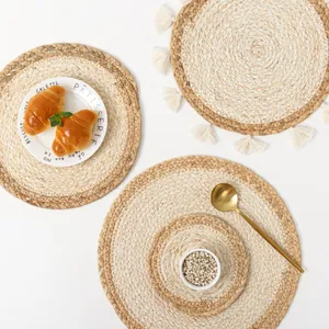Macro detail of handmade woven straw placemats with dual-tone texture and fringe