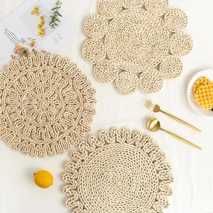 Detailed close-up of three hand-woven corn husk heat-resistant placemats with floral patterns