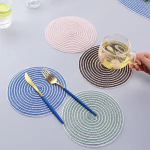 Detail of round woven heat-resistant table mats in pink, blue, brown, and green colors
